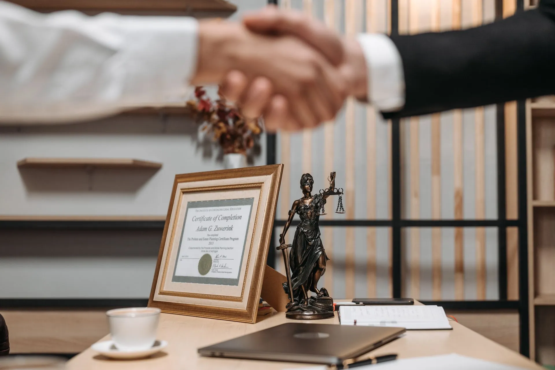 An attorney and client shaking hands in a law office