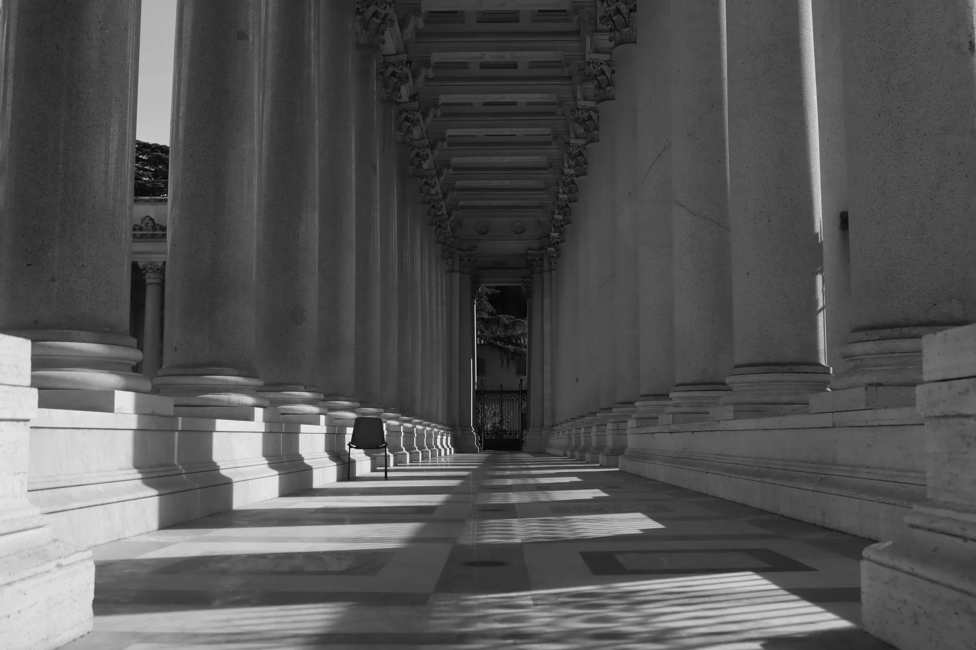 Sunlight falling through a classical stone colonnade